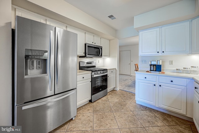 kitchen with white cabinetry, stainless steel appliances, and light tile patterned flooring