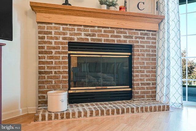 details with a brick fireplace and hardwood / wood-style flooring