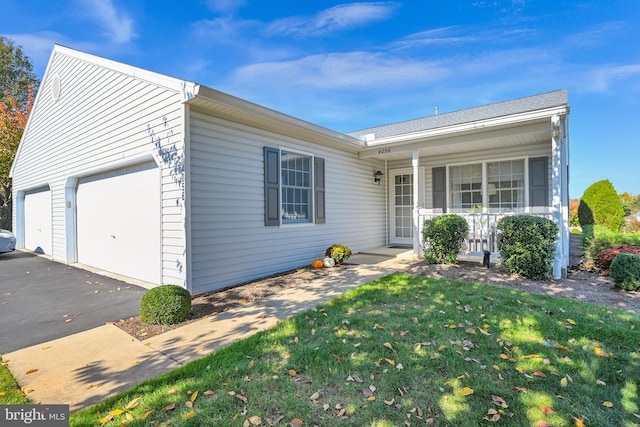 single story home featuring a front lawn, covered porch, and a garage