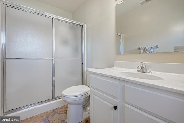 bathroom featuring vanity, toilet, and a shower with door