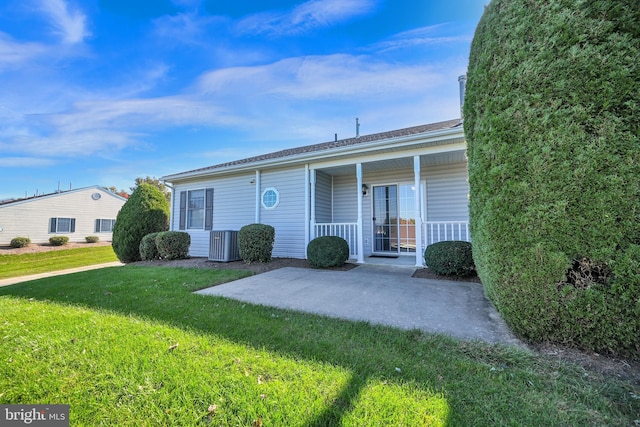 view of front of home featuring central air condition unit, a front yard, and a porch