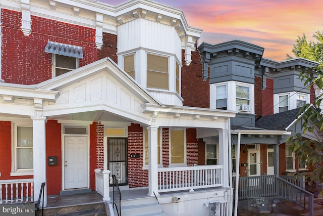 townhome / multi-family property featuring a porch and cooling unit