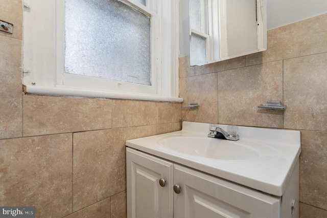 bathroom with vanity and tile walls