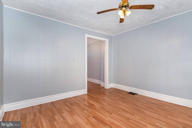 unfurnished room with a textured ceiling, light hardwood / wood-style floors, and ceiling fan