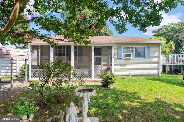 view of front of house featuring a sunroom, a deck, and a front lawn