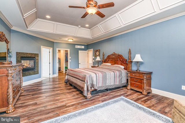 bedroom with wood finished floors, visible vents, baseboards, coffered ceiling, and ornamental molding