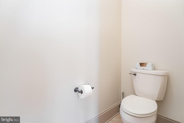 bathroom with tile patterned floors, toilet, and baseboards