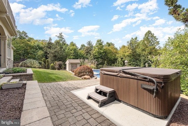 view of patio / terrace with an outbuilding and a hot tub