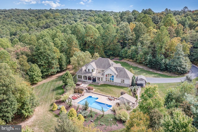 drone / aerial view with a wooded view