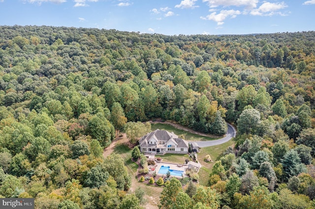 drone / aerial view featuring a wooded view