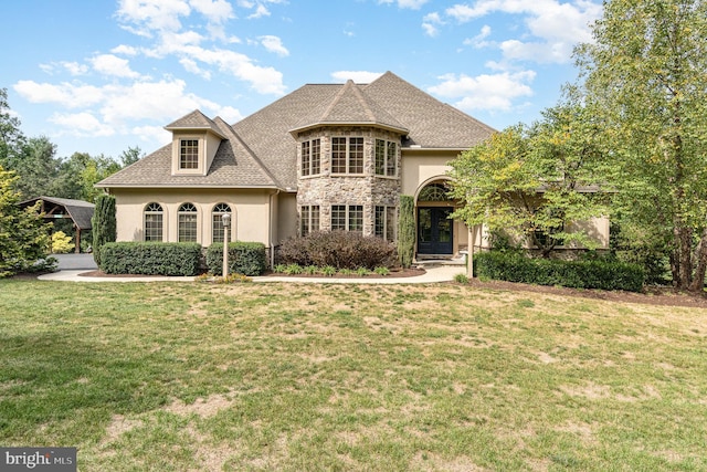 french provincial home featuring a detached carport, stone siding, stucco siding, and a front lawn