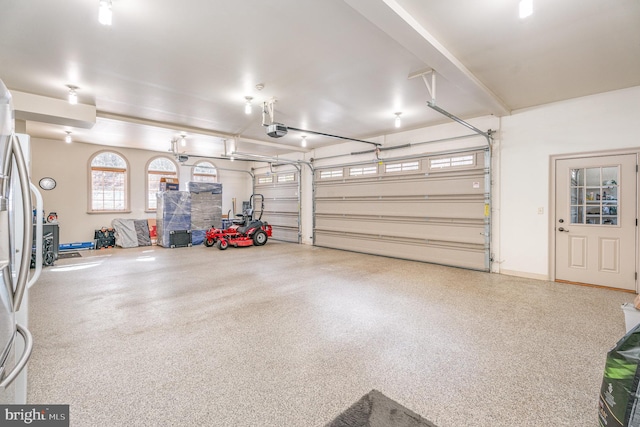 garage featuring freestanding refrigerator and a garage door opener