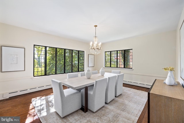 dining room featuring an inviting chandelier, light hardwood / wood-style flooring, and a baseboard heating unit