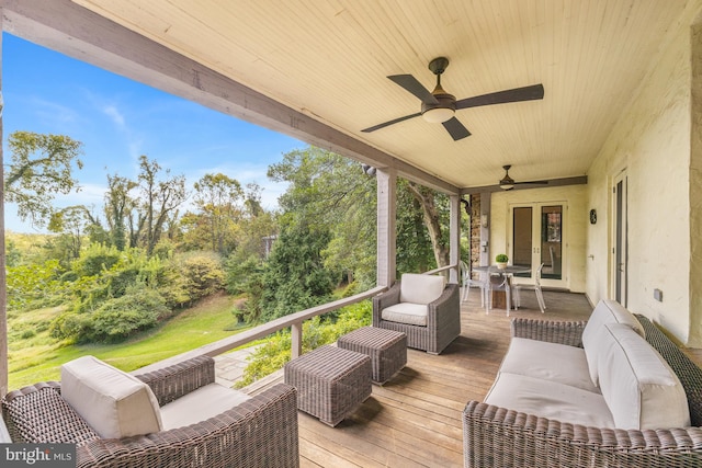 wooden terrace featuring an outdoor living space and ceiling fan