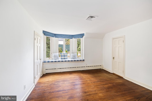 spare room featuring a baseboard radiator and dark hardwood / wood-style flooring