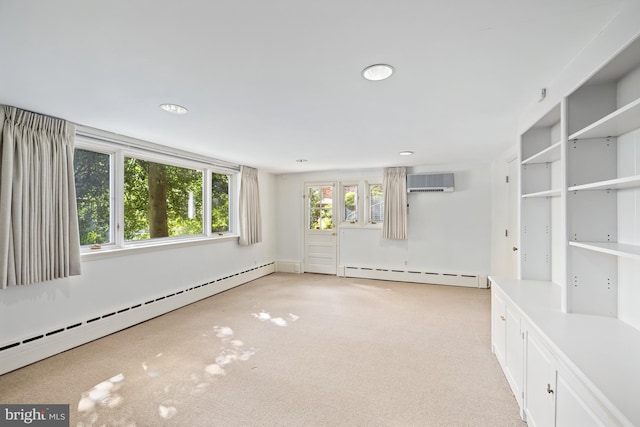 carpeted spare room featuring a baseboard radiator and a wall mounted air conditioner