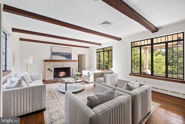 living room with a stone fireplace, hardwood / wood-style floors, beam ceiling, and a baseboard heating unit