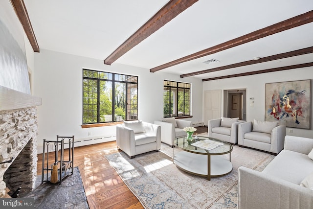 living room with beam ceiling, a fireplace, light wood-type flooring, and baseboard heating