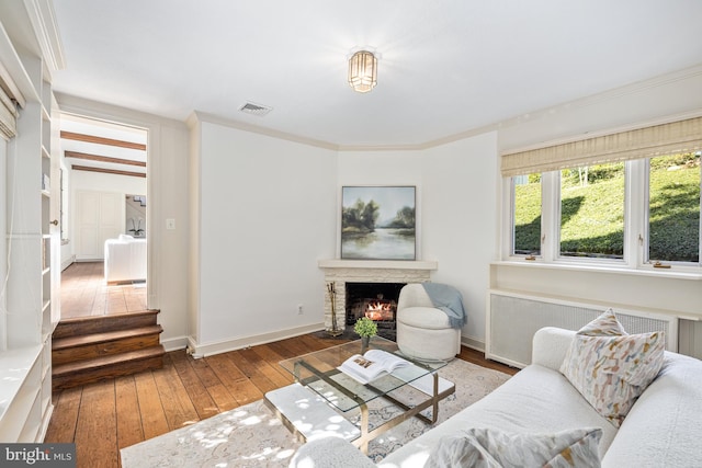 living room featuring radiator, ornamental molding, and hardwood / wood-style floors