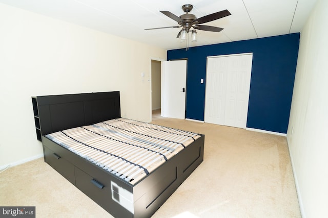 bedroom featuring light carpet, a closet, and ceiling fan