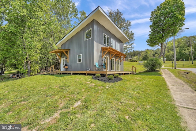 exterior space featuring a wooden deck and a lawn