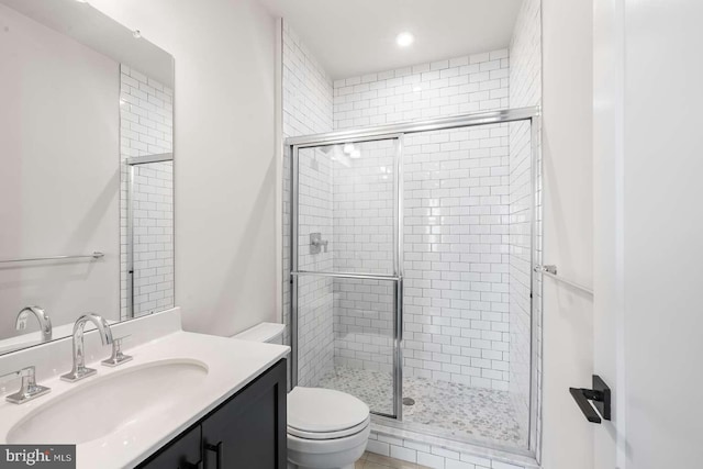 bathroom with vanity, toilet, and walk in shower