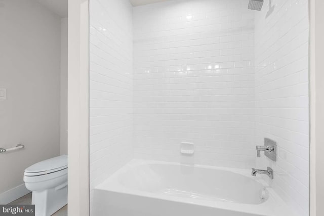 bathroom with toilet and tiled shower / bath combo