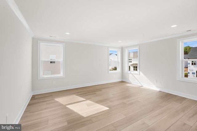 empty room with crown molding and light wood-type flooring