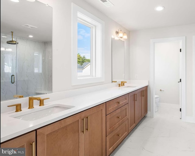 bathroom featuring toilet, vanity, and a shower with door