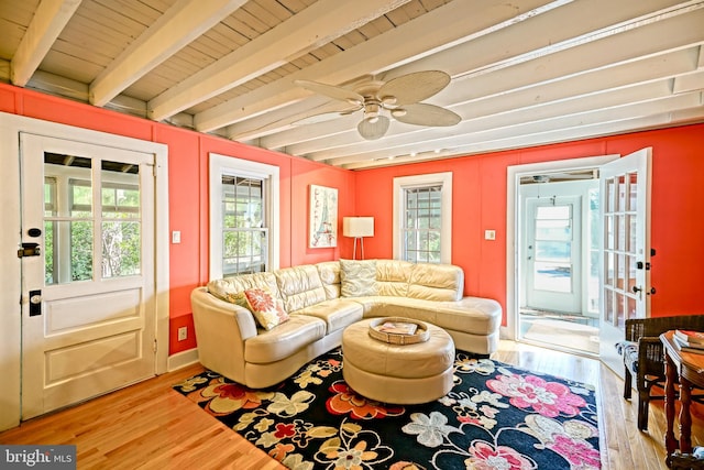 living room featuring light wood-type flooring, beam ceiling, plenty of natural light, and ceiling fan