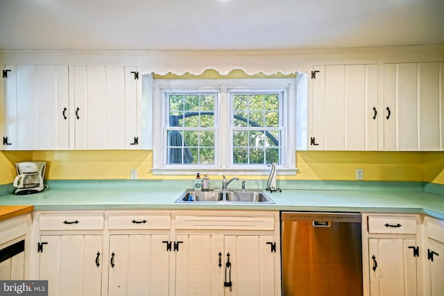 kitchen featuring stainless steel dishwasher, sink, and white cabinets