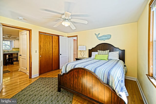 bedroom featuring sink, hardwood / wood-style flooring, a closet, and ceiling fan