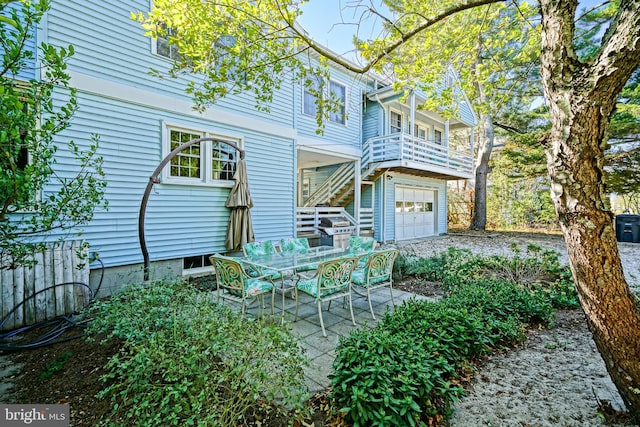 exterior space featuring a patio, a garage, and a balcony