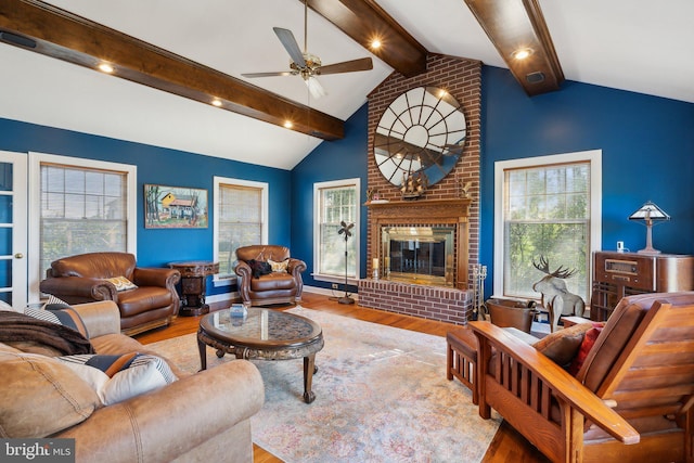 living room featuring ceiling fan, lofted ceiling with beams, a fireplace, and hardwood / wood-style floors