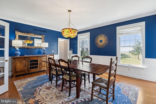 dining area with crown molding and wood-type flooring