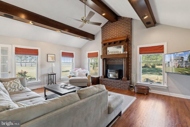 living room featuring a wood stove, wood-type flooring, vaulted ceiling with beams, and ceiling fan