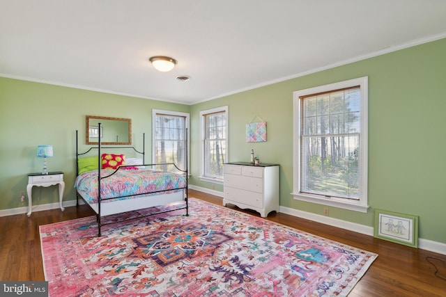 bedroom with crown molding, multiple windows, and dark hardwood / wood-style floors