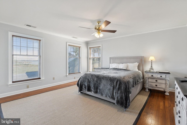 bedroom with dark wood-type flooring, crown molding, and ceiling fan