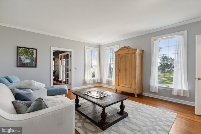 living room with ornamental molding, wood-type flooring, and a wealth of natural light