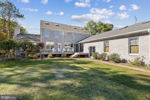 back of property with a deck and a lawn