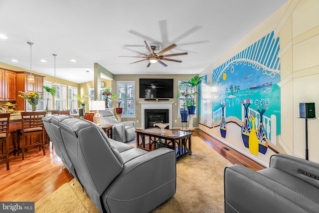 living room with light wood-type flooring and ceiling fan