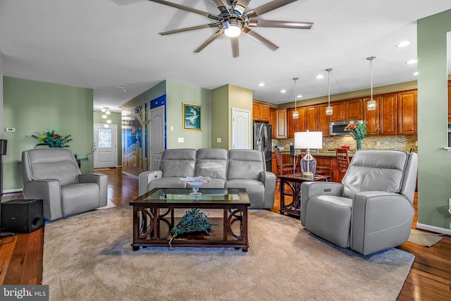 living room with ceiling fan and light hardwood / wood-style flooring