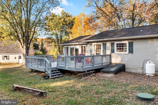 rear view of house featuring a deck and a lawn