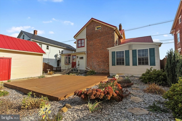 rear view of house featuring a wooden deck and a storage shed