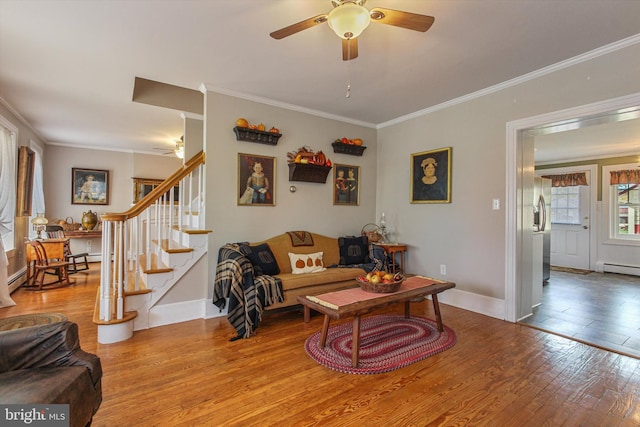 living room featuring ornamental molding, a baseboard heating unit, hardwood / wood-style flooring, and ceiling fan