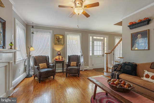 living room with ornamental molding, light hardwood / wood-style flooring, a baseboard heating unit, and ceiling fan