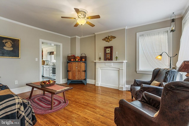 living room featuring ceiling fan, wood-type flooring, and ornamental molding