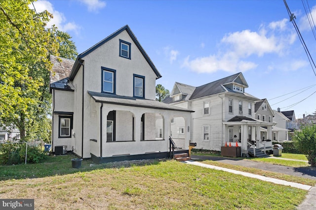 view of front of property with a front yard and cooling unit