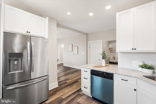 kitchen with backsplash, stainless steel appliances, dark hardwood / wood-style floors, and white cabinets