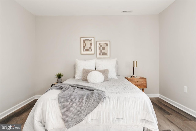 bedroom with dark hardwood / wood-style floors